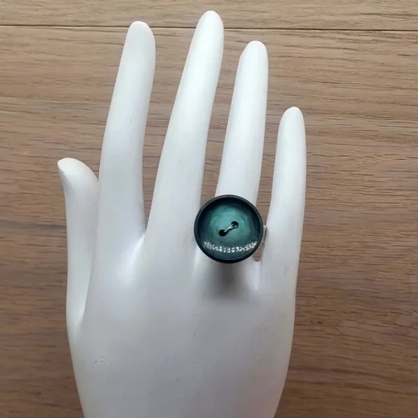 Auffäliger Ring aus massivem Silber mit grünem Knopf.