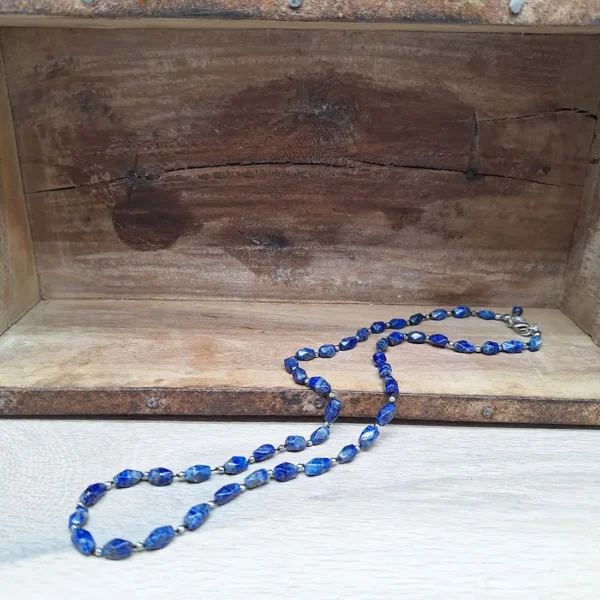 Wunderschöne blaue Perlenkette aus Oval-eckigen Lapsilazuli Perlen und winzig kleinen versilberten Perlen. Handgeknüpft