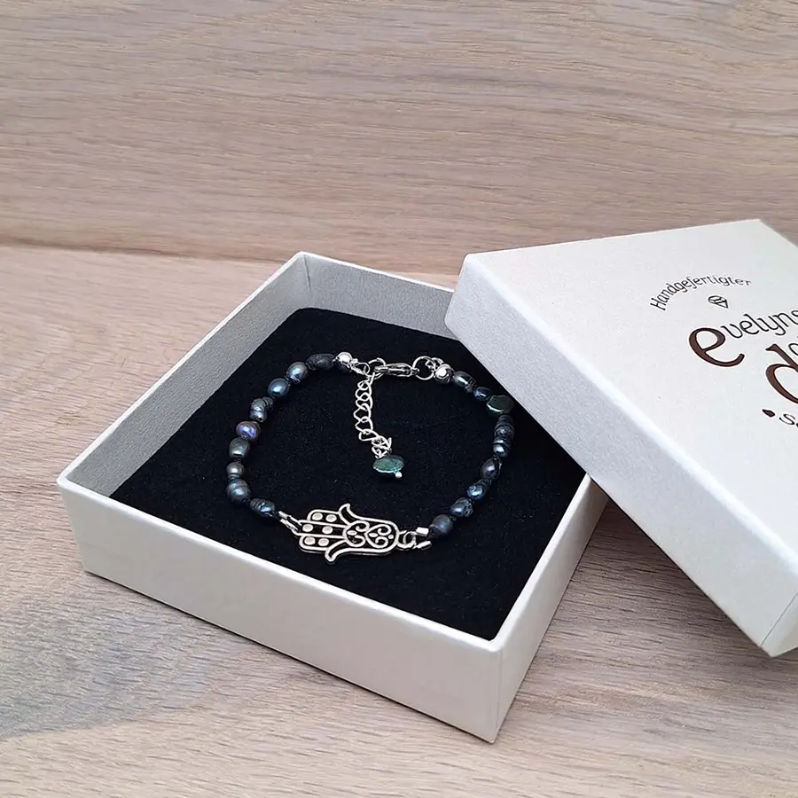 Armband mit blauen Perlen - echten Süßwasserperlen. In der Mitte ist das Armband verziert mit einem versilberten Hamsa Symbol.
