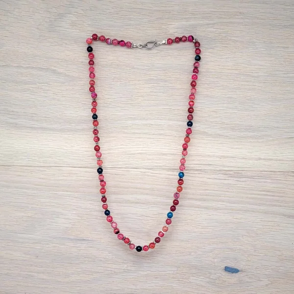 Handgefertigte Perlenkette, ganz klassisch hergestellt aus kleinen Knoten. Schöne Farben in Rot, Pink und Blau